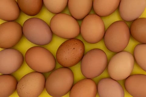 Easter eggs laying on a yellow background creating a pattern 스톡 사진
