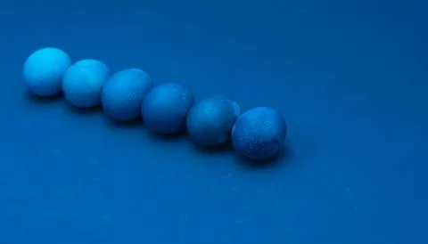 Easter eggs layout on blue background. ombre effect. classic blue monochromat Stock Photos