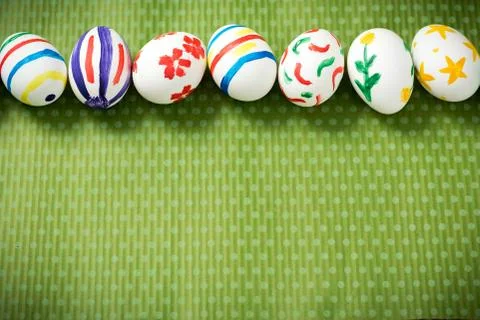 Easter eggs lie on a green background Stock Photos