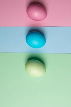 Easter eggs lie on three colored backgrounds Stock Photos