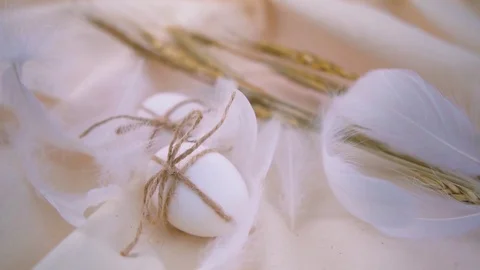 Easter eggs on a light background, feathers around are swaying from the wind. Stock Footage 122313115