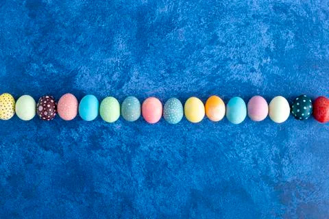 Easter eggs in line on dark blue background. Holiday decorations, Easter conc Stock Photos
