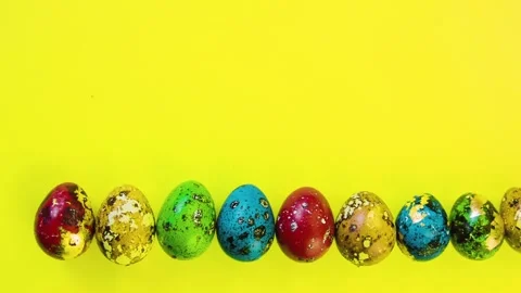 Easter eggs lined in a row on a yellow bright background.  Video stock 86763190