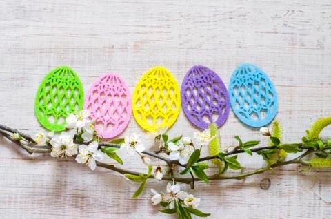 Easter eggs made of colored felt with flowering branches of fruit tree. Stock Photos