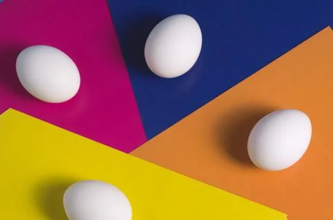 Easter eggs on a multicolored background of yellow, blue, pink and orange Stock Photos