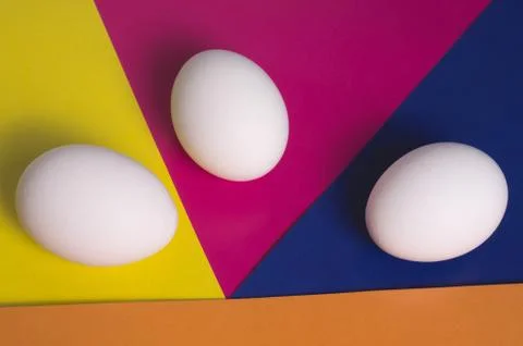 Easter eggs on a multicolored background of yellow, blue, pink and orange Stock Photos