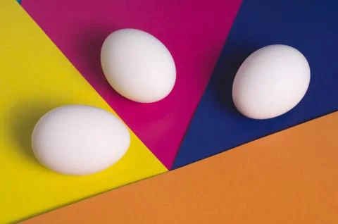 Easter eggs on a multicolored background of yellow, blue, pink and orange Stock Photos