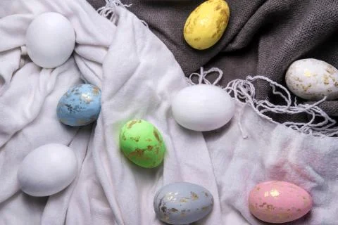 Easter eggs multicolored on the fabric. Easter background with eggs and feath Stock Photos