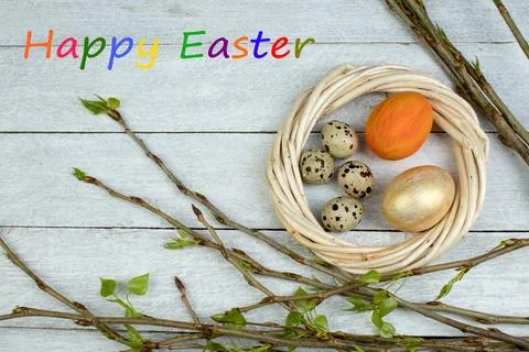 Easter eggs, nest and branch with leaves on wooden table background. Top vi.. Foto stock