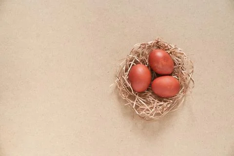Easter eggs, in a nest on a beige background. Minimal concept. Top view. With Stock Photos