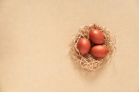 Easter eggs, in a nest on a beige background. Minimal concept. Top view. With Stock Photos
