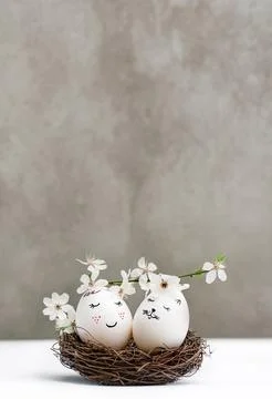 Easter eggs in nest with blooming cherry branch Stock Photos