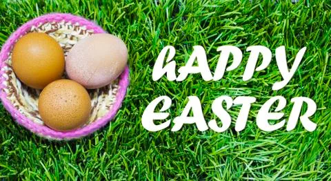 Easter eggs in nest on grass with text: Happy easter. Stock Photos