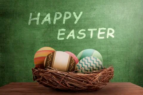 Easter eggs in nest with happy easter greeting Stock Photos