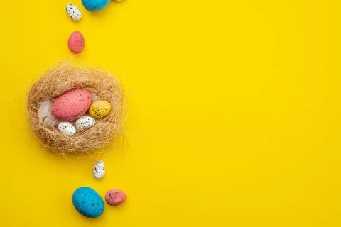 Easter eggs in nest over yellow background. View with copy space Stock Photos