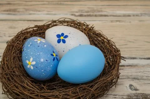 Easter eggs in a nest on a rustic background, close up view Stock Photos