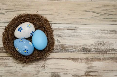 Easter eggs in a nest, on a rustic background, top view Stock Photos