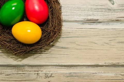 Easter eggs in a nest, on a rustic background. Top view Stock Photos