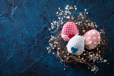 Easter eggs in the nest on rustic dark blue background Stock Photos