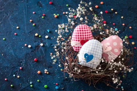 Easter eggs in the nest on rustic dark blue background Stock Photos