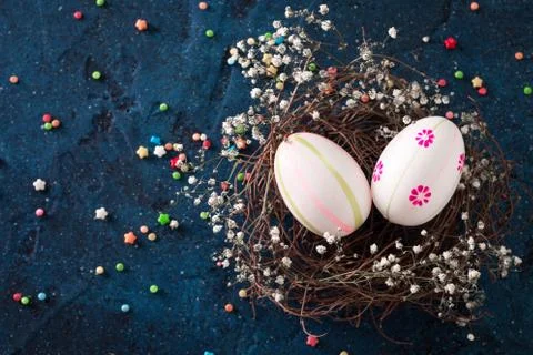 Easter eggs in the nest on rustic dark blue background Foto stock