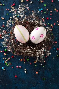 Easter eggs in the nest on rustic dark blue background Stock Photos