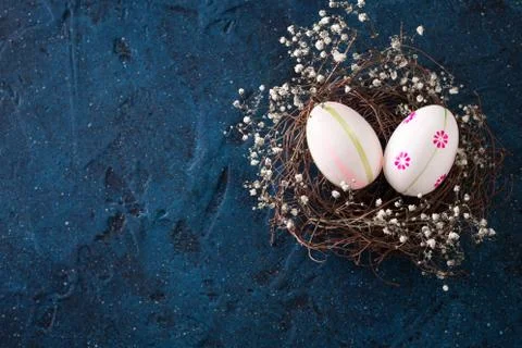 Easter eggs in the nest on rustic dark blue background Foto stock