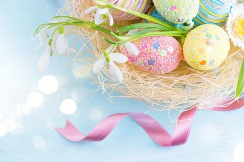 Easter eggs in the nest with spring flowers over wooden background Fotos Stock