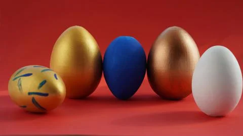 Easter eggs painted in different colors on a red background macro Stock Photos