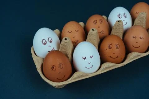 Easter eggs with painted funny faces in carton container box isolated on dark Stock Photos