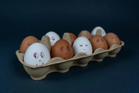 Easter eggs with painted funny faces in carton container box isolated on dark Stock Photos