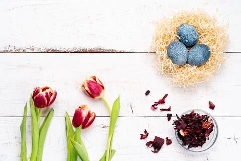 Easter eggs, painted with natural dyes, hibiscus flowers, karkade tea, on a w Stock Photos