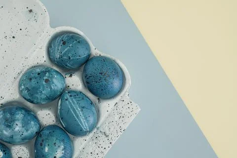 Easter eggs painted in the night sky in an egg container on a two-colored pastel Stock Photos