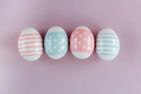 Easter eggs in pastel colors with a pattern on a pink background. Stock Photos