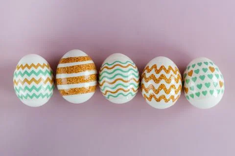 Easter eggs in pastel colors with a pattern on a pink background. Stock Photos
