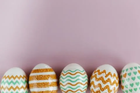 Easter eggs in pastel colors with a pattern on a pink background. Stock Photos