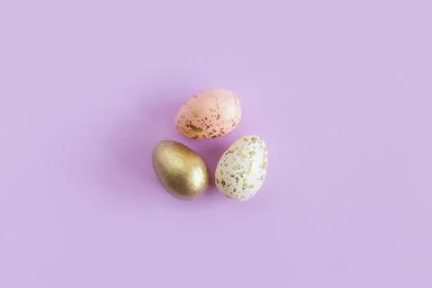 Easter eggs on a pastel violet background. Pastel colors.  Flat lay. Place fo Stock Photos