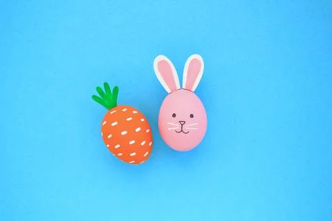 Easter eggs pattern made with carrot and bunny on blue background Stock Photos