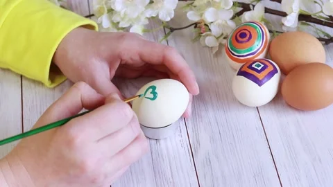 Easter eggs. Preparation for the holiday, paint eggs with paints, draw hearts Video stock 234123405