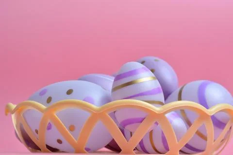 Easter eggs of purple color with patterns in a basket. Pink background. Easte 库存照片