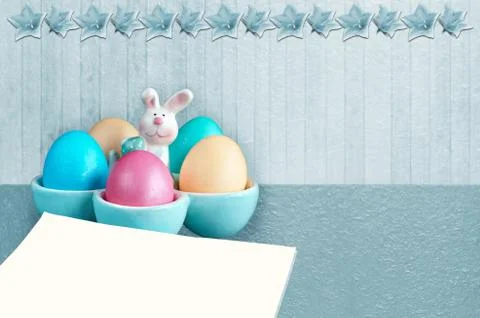 Easter eggs in a rabbit-shaped stand and a blank sheet of paper . Monochrome 스톡 사진