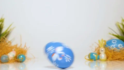 Easter eggs roll on the table, white background, loopable Stock-Footage 123532594