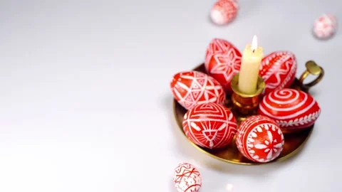 Easter eggs rolled up to candlestick and red eggs with folk white pattern Stock Footage 127886897