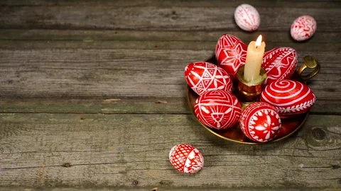 Easter eggs rolled up to candlestick with red eggs with folk white pattern Stock-Footage 127887053