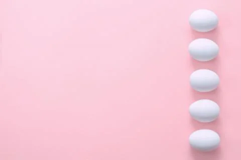 Easter eggs in a row on a pink background. Easter creative greeting card. Stock Photos