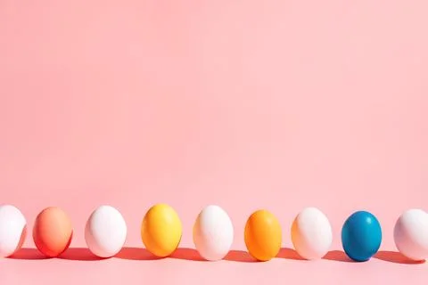 Easter eggs row on pink background with copy space, minimal composition 스톡 사진
