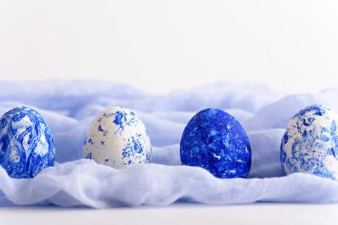 Easter eggs in row of white and classic blue on soft blue towel on white back Stock Photos
