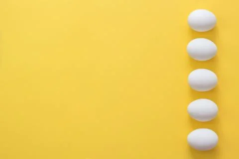 Easter eggs in a row on a yellow background. Stock Photos
