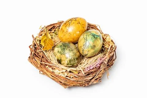 Easter eggs in rustic nest close up. Festive easter egg nest on white backgro Stock Photos