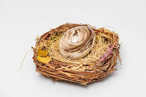 Easter eggs in rustic nest close up. Festive easter egg nest on white background Stock Photos